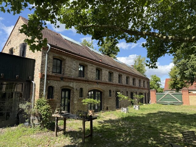Backsteingebäude des Hof Eversmann — historischer Vierseitenhof mit Bogenfenstern und Ziegelfassade im Sommer